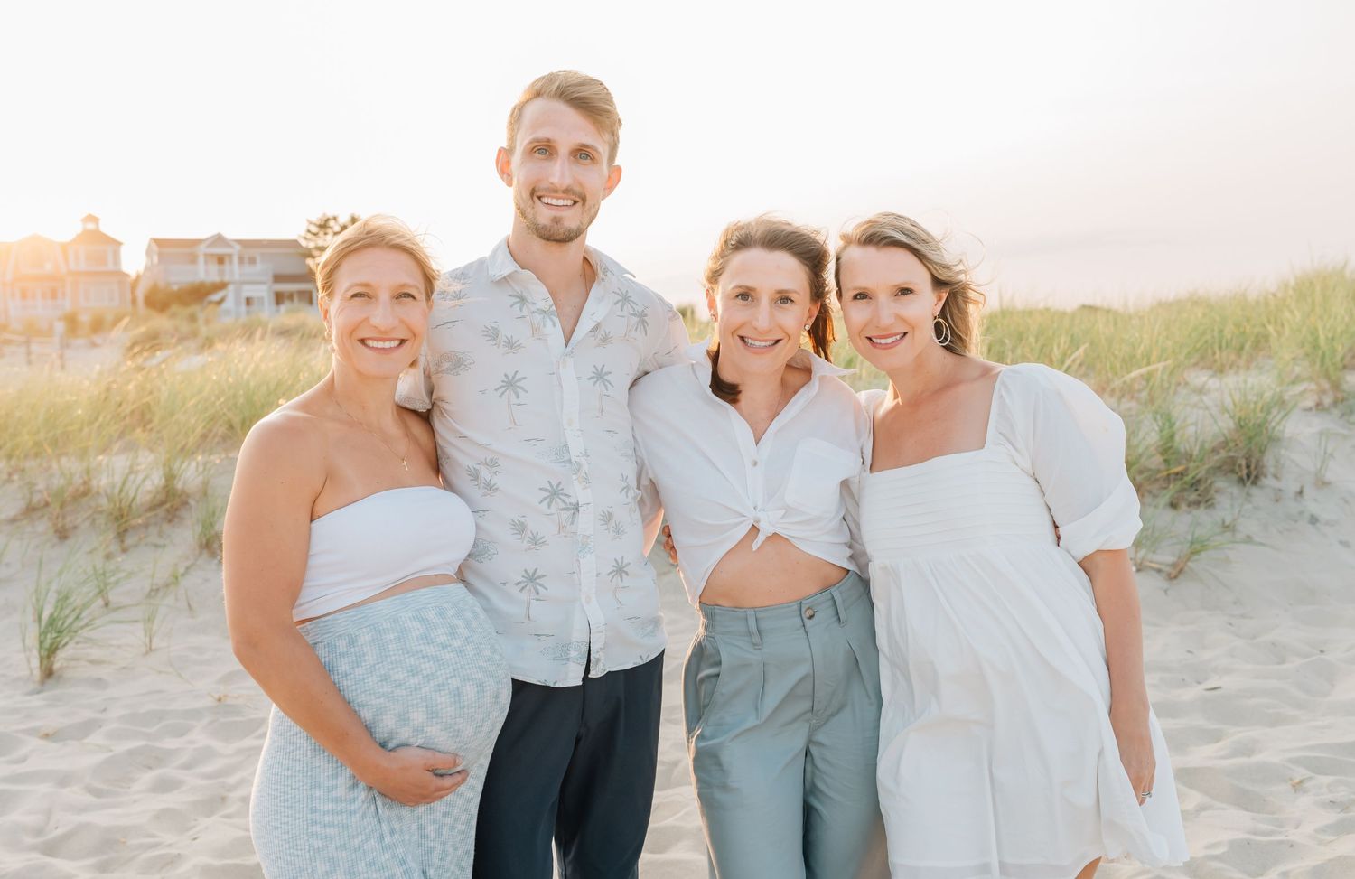 sibling pose together on the beach in spring lake nj for a family photo.