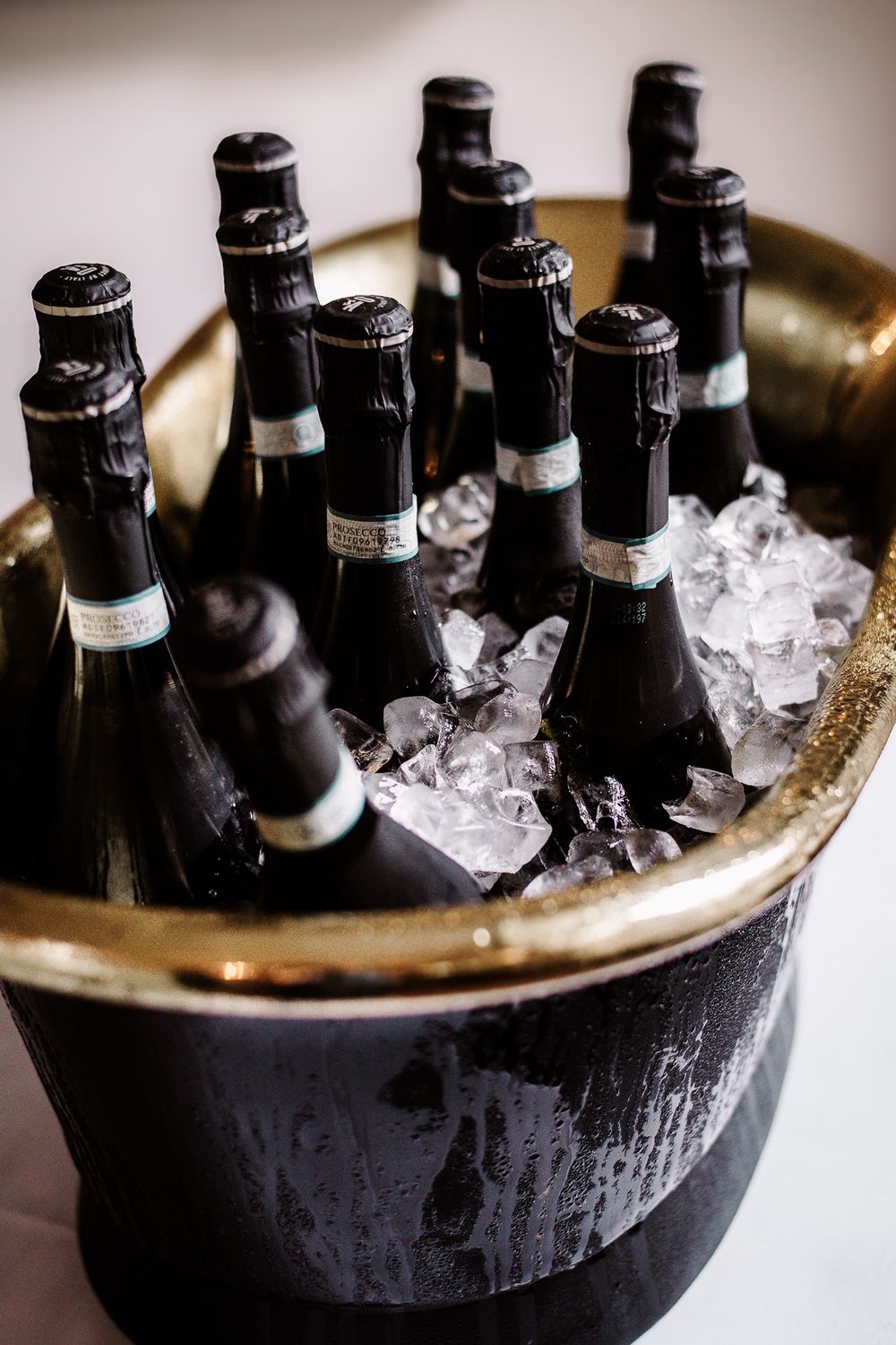 Dark glass bottles chilling in ice in a black bucket or container.