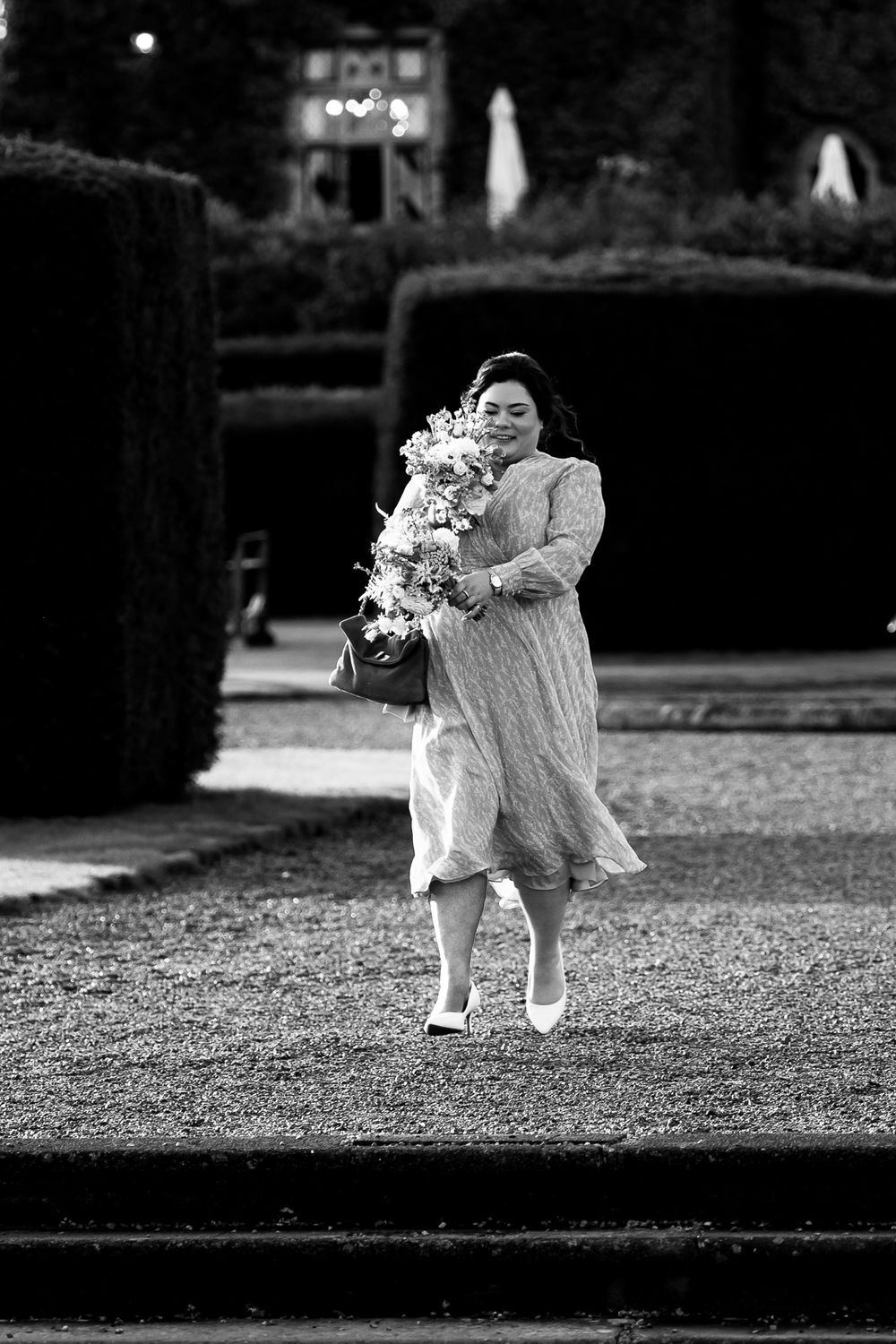 Black and white sequence of a flower girl walking and dropping petals on the ground during a wedding ceremony.