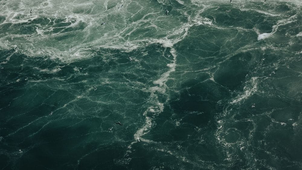 Turbulent waves of blue-green water churning in a powerful current.