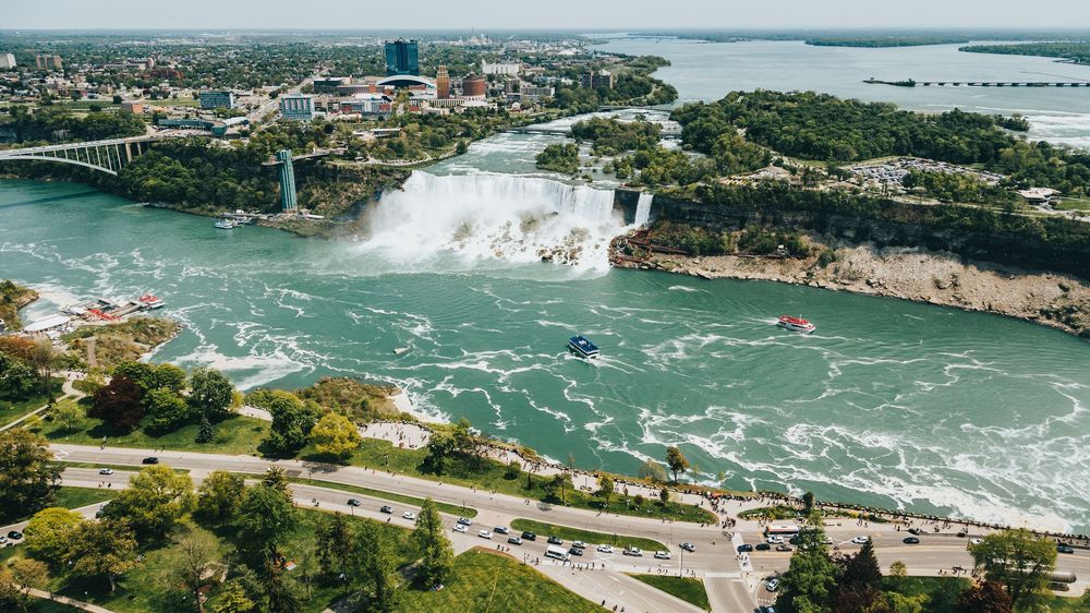 Aerial panorama of Niagara Falls and surrounding cityscape with waterfront views.