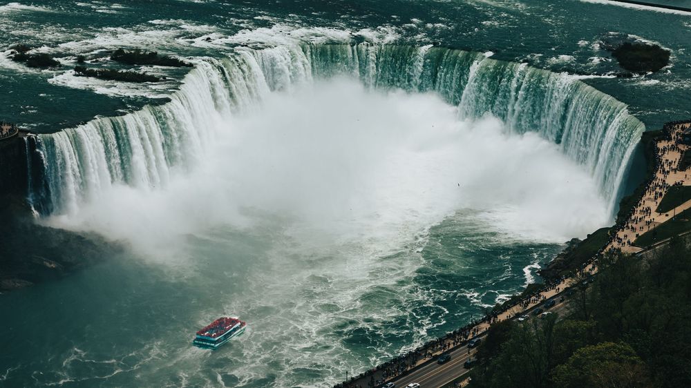 Panoramic view of Niagara Falls showcasing the massive horseshoe curve and rising mist.