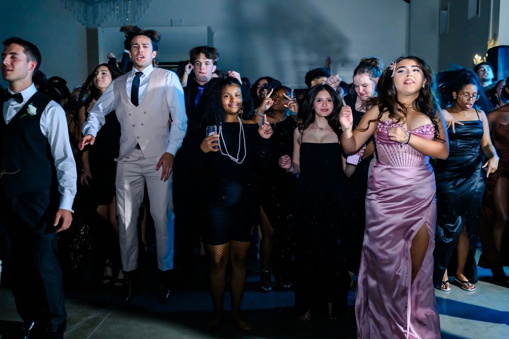 Diverse group of partygoers dancing and celebrating at an elegant evening event.