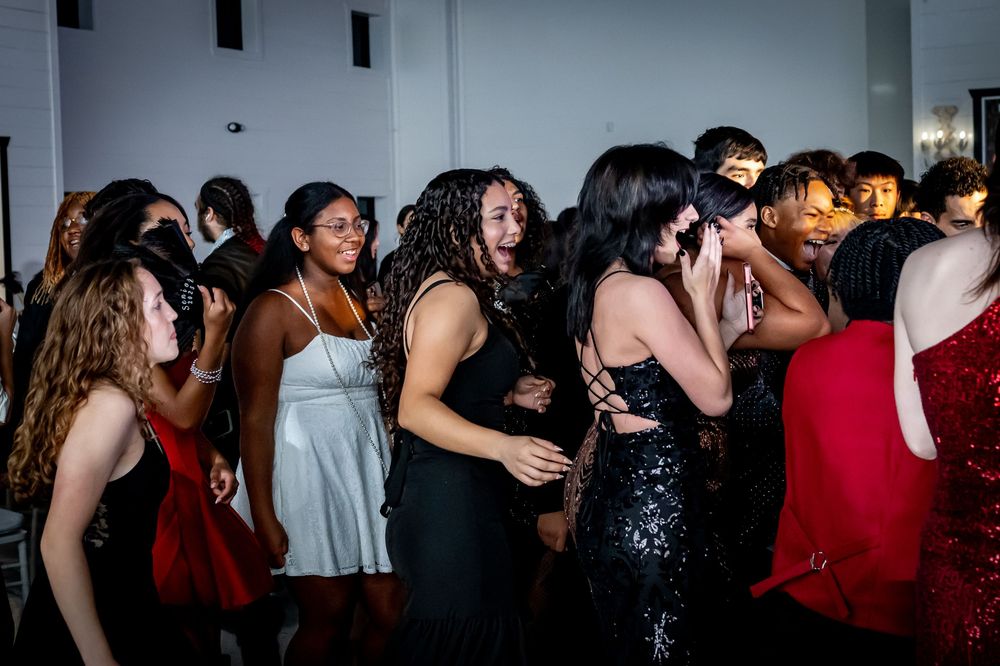Diverse group of guests dancing and celebrating at a formal event reception.