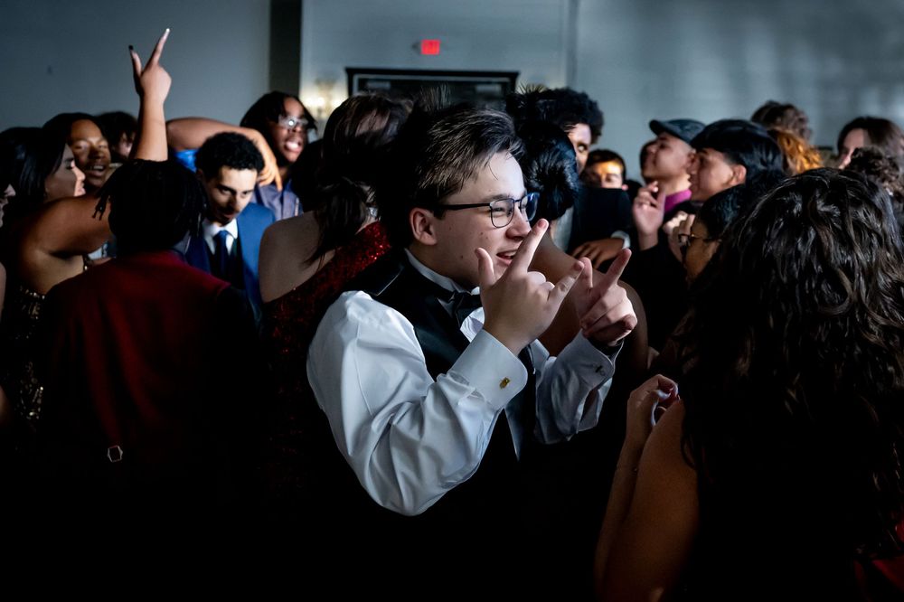 People dancing together in a dimly lit room during a celebration or party.