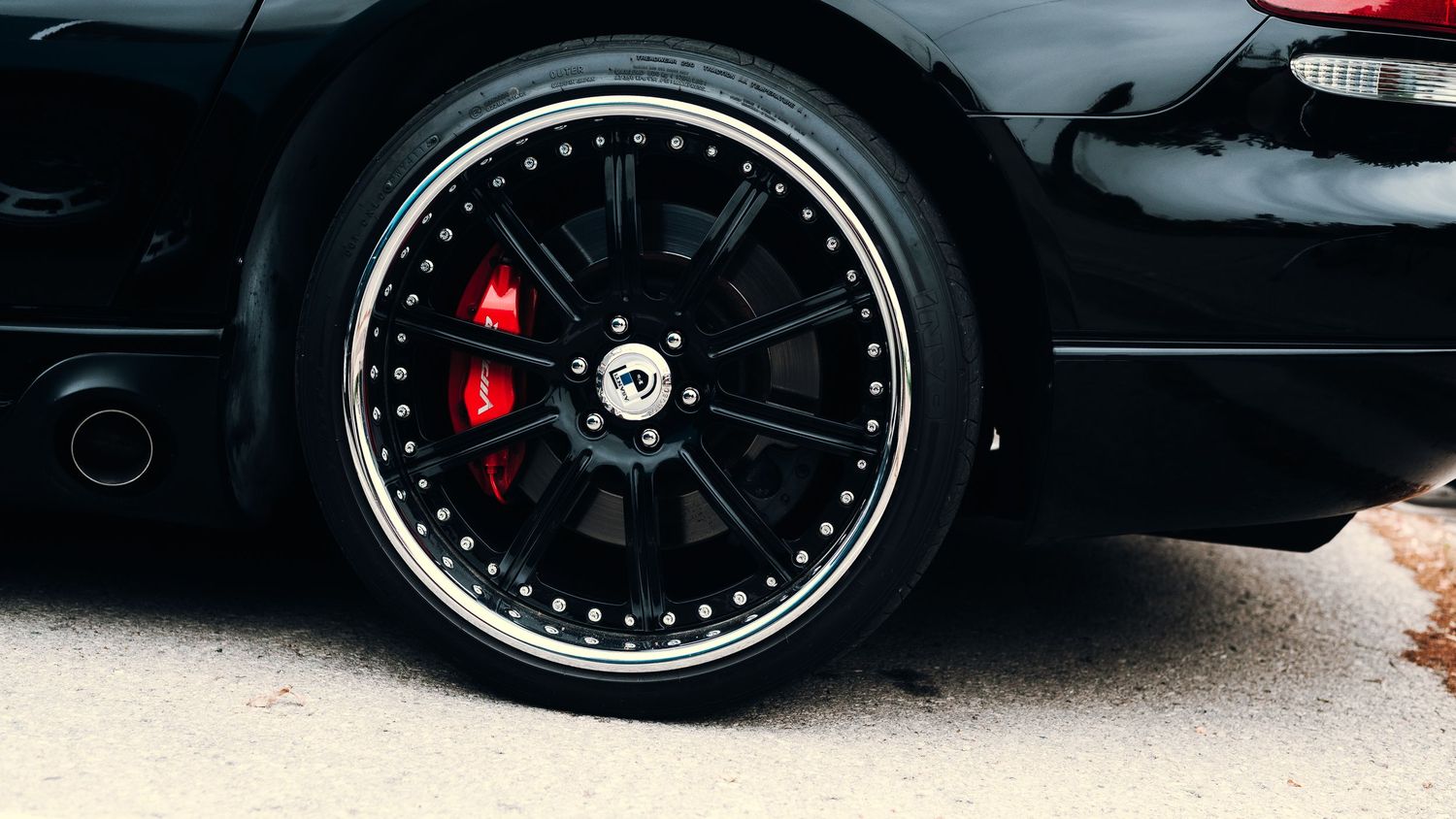 Custom black wheels with red brake calipers on a performance vehicle.