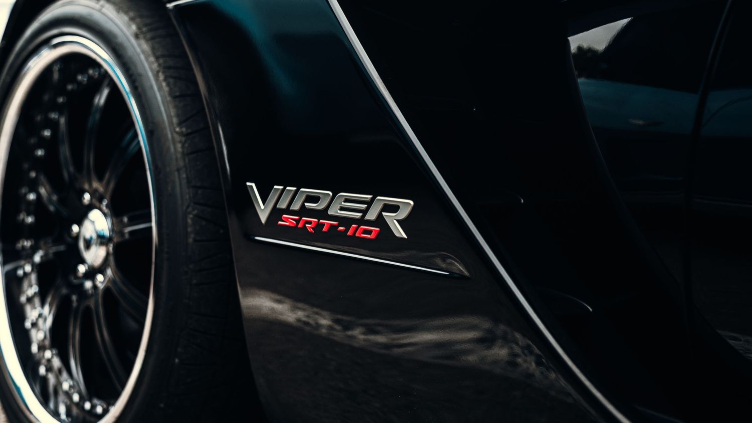 Detail shots of black sports car with Viper badging and custom wheels.
