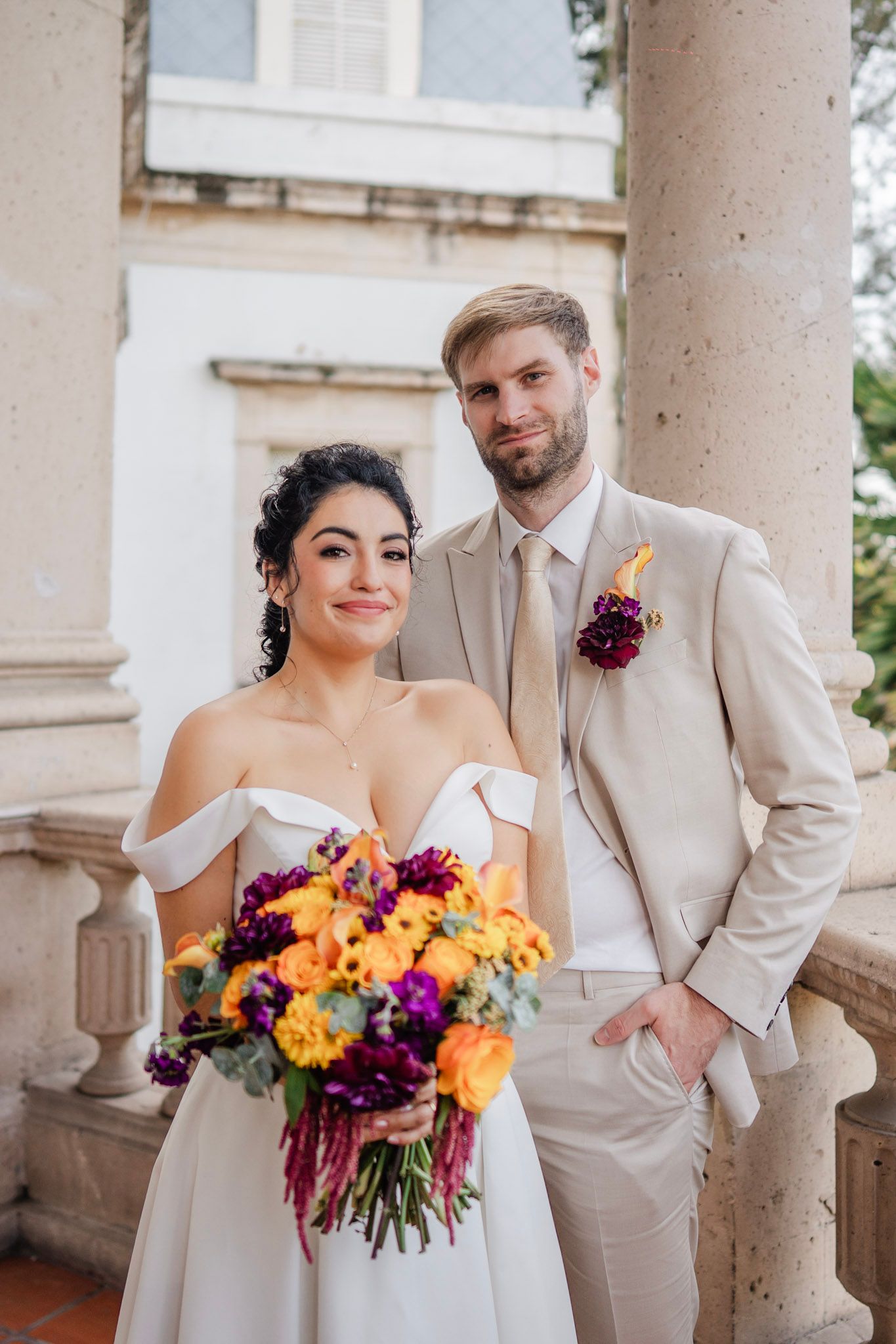 Elegante pareja posando en un estudio blanco brillante con decoración clásica.