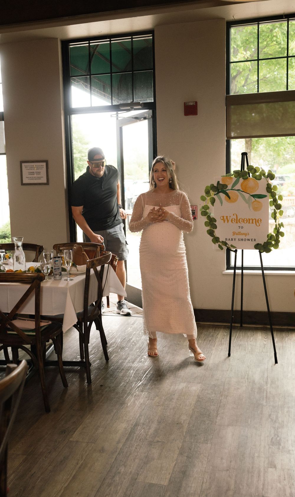 Interior event space with hardwood floors and large windows showing celebratory decorations.