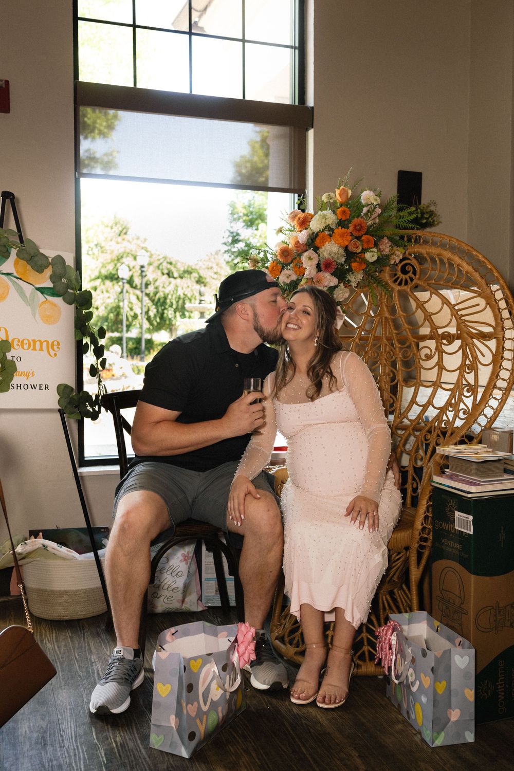 A couple sharing a tender moment while seated in a rattan peacock chair.