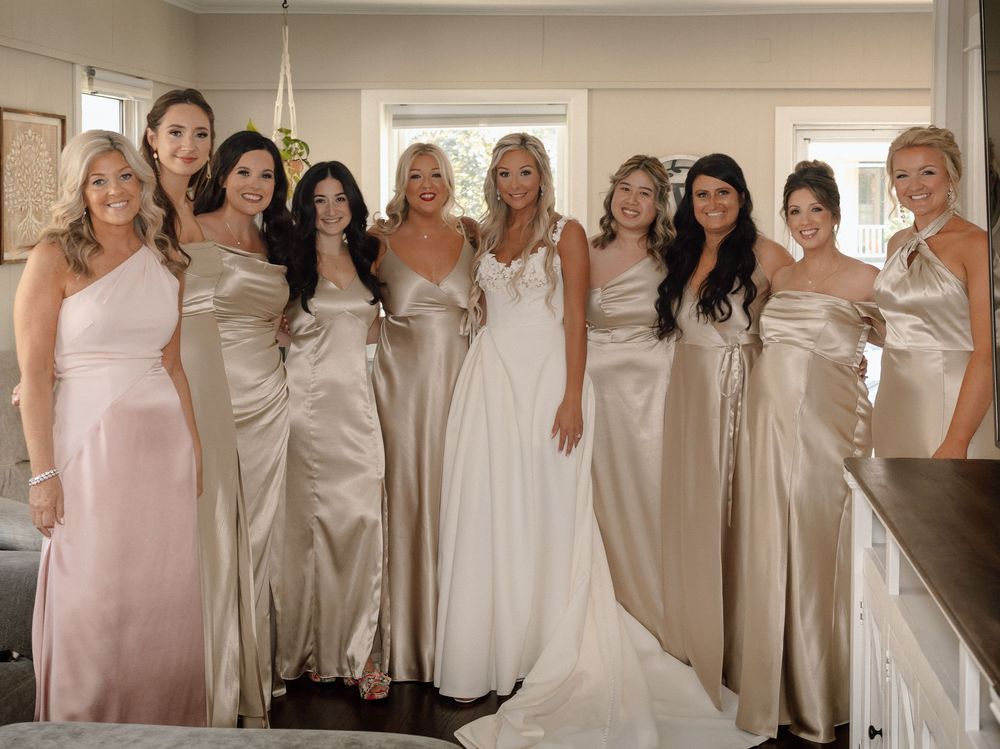 Group photo of bridesmaids wearing coordinated neutral-toned dresses.