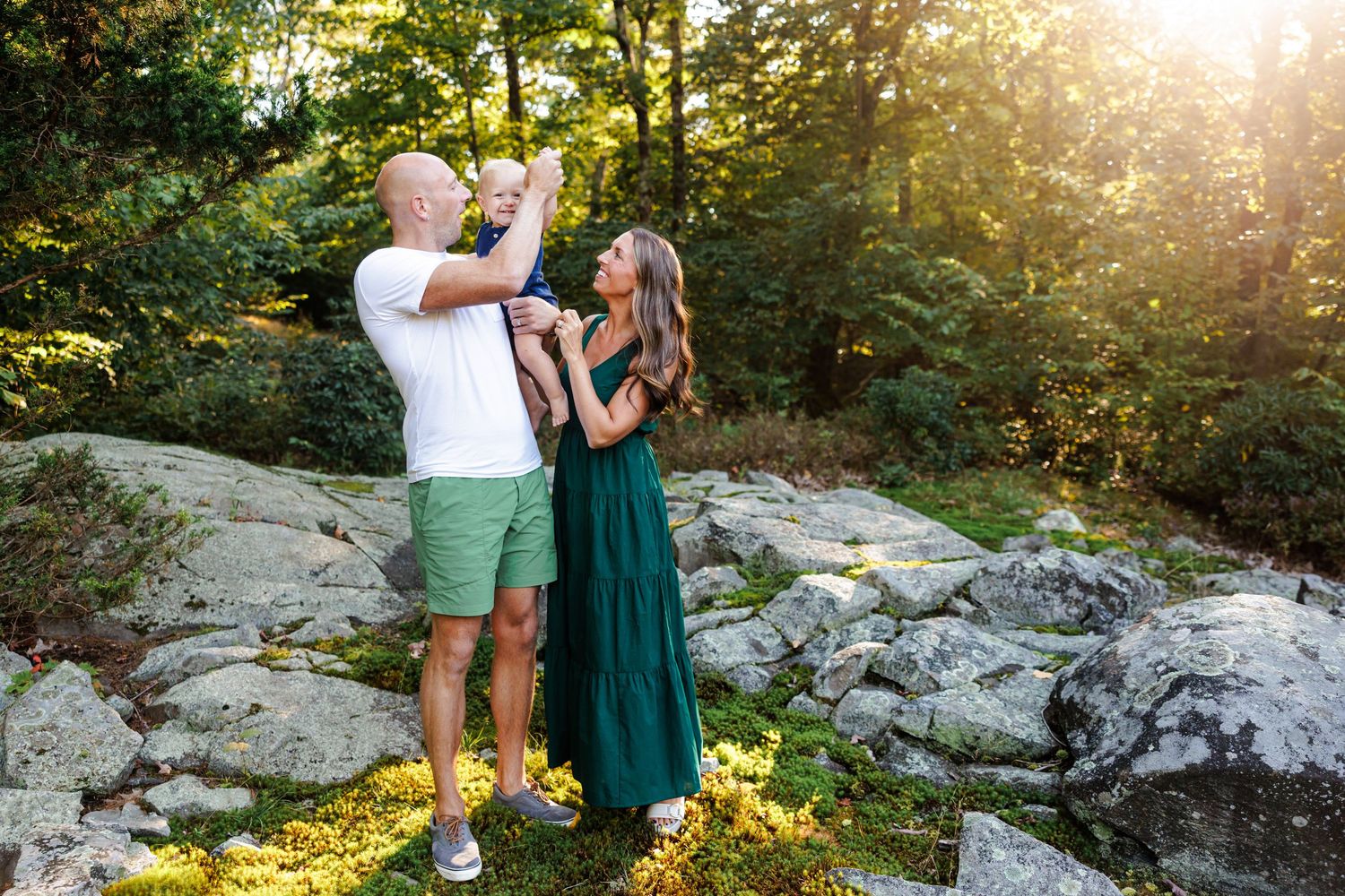 Couple sharing intimate moment on rocky overlook during golden sunset.