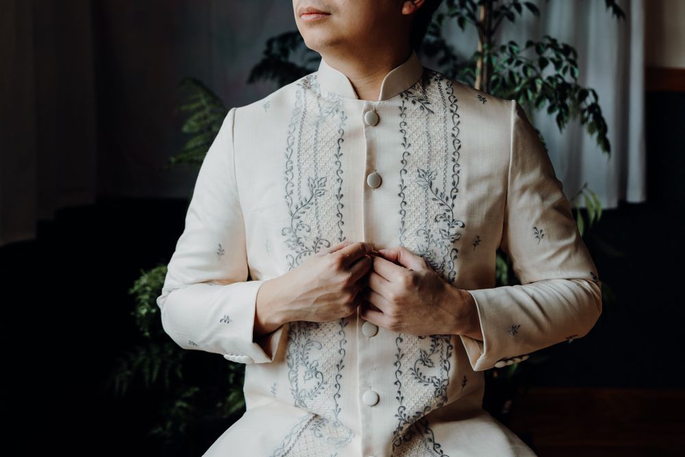 Traditional embroidered white Barong Tagalog formal wear with detailed stitching.