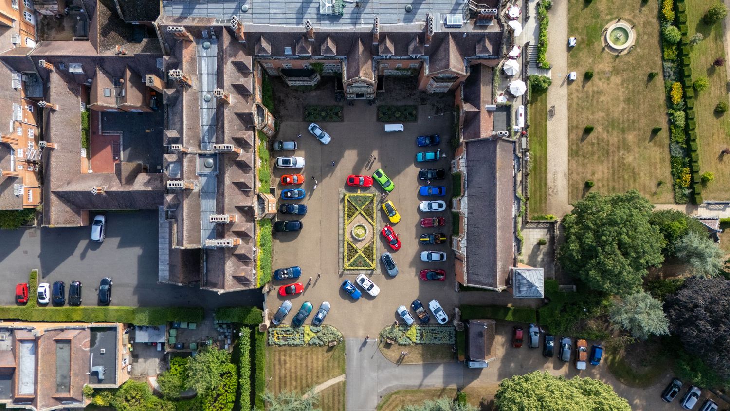 Aerial panoramic view of residential neighborhood with parked cars.