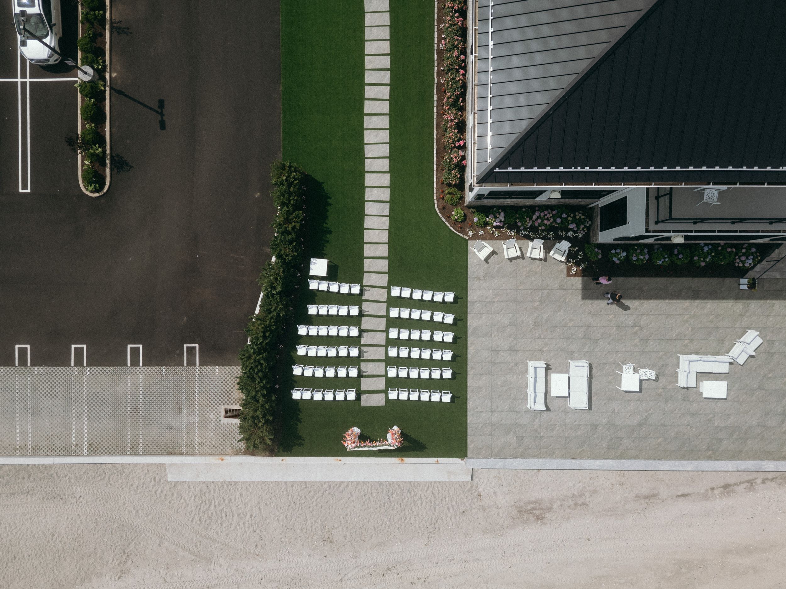Aerial view of a large industrial warehouse facility with loading docks and parking areas surrounded by grass.