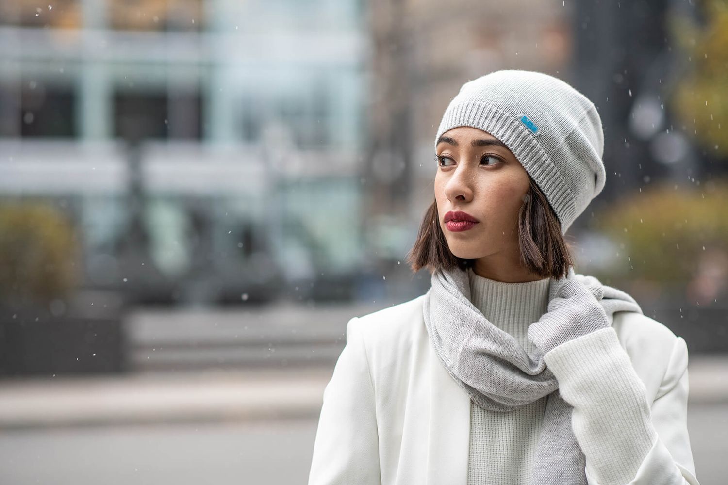 A collage of winter fashion photos showing models in white coats and gray beanies posing outdoors in an urban setting.  Montreal, Canada