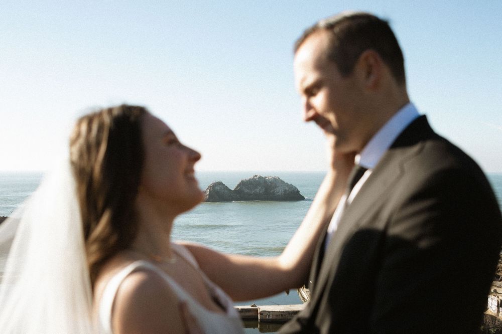 Couple shares intimate moments during their beach wedding ceremony at sunset.