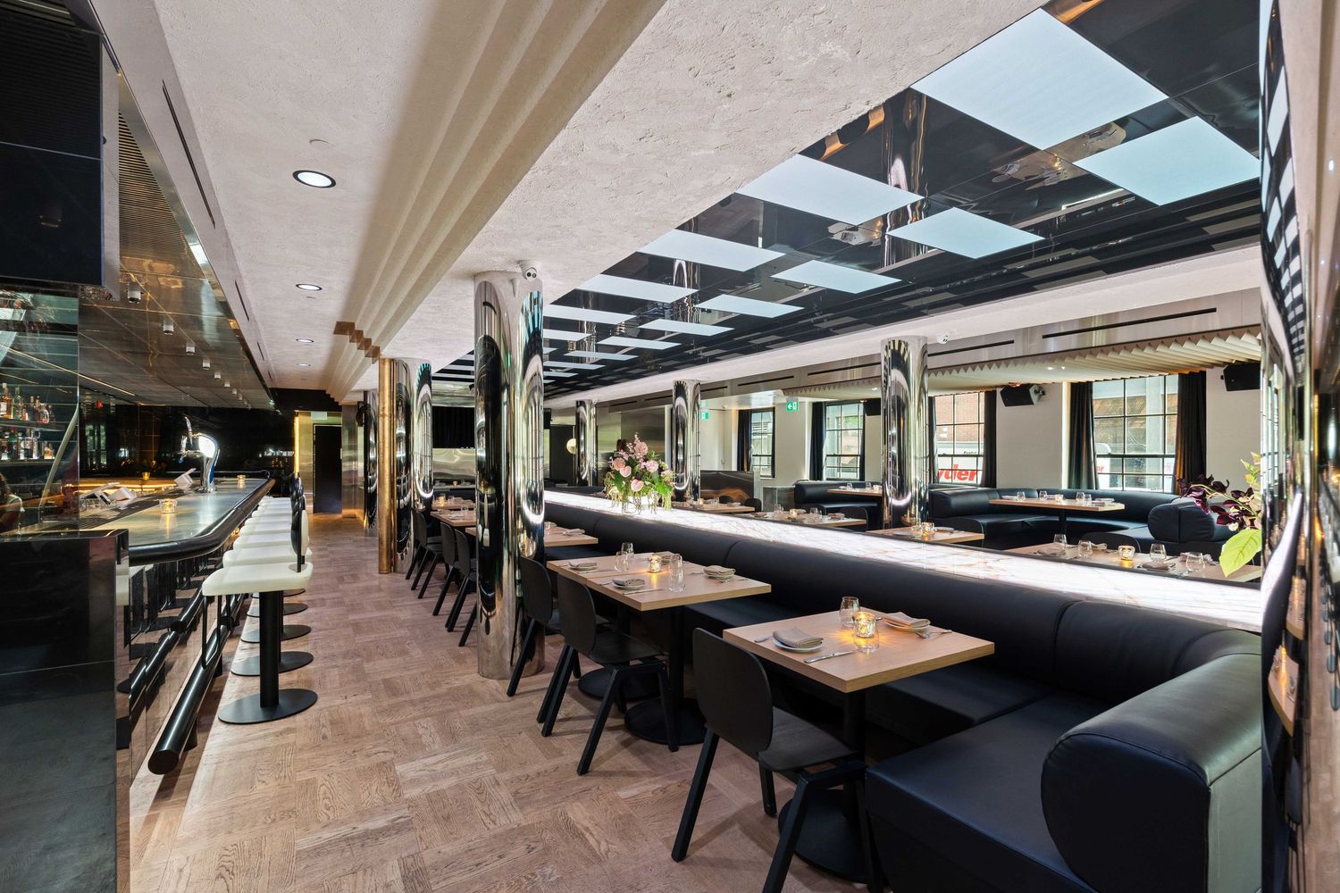 Modern restaurant interior with sleek black seating and ambient lighting showcases contemporary dining space design.