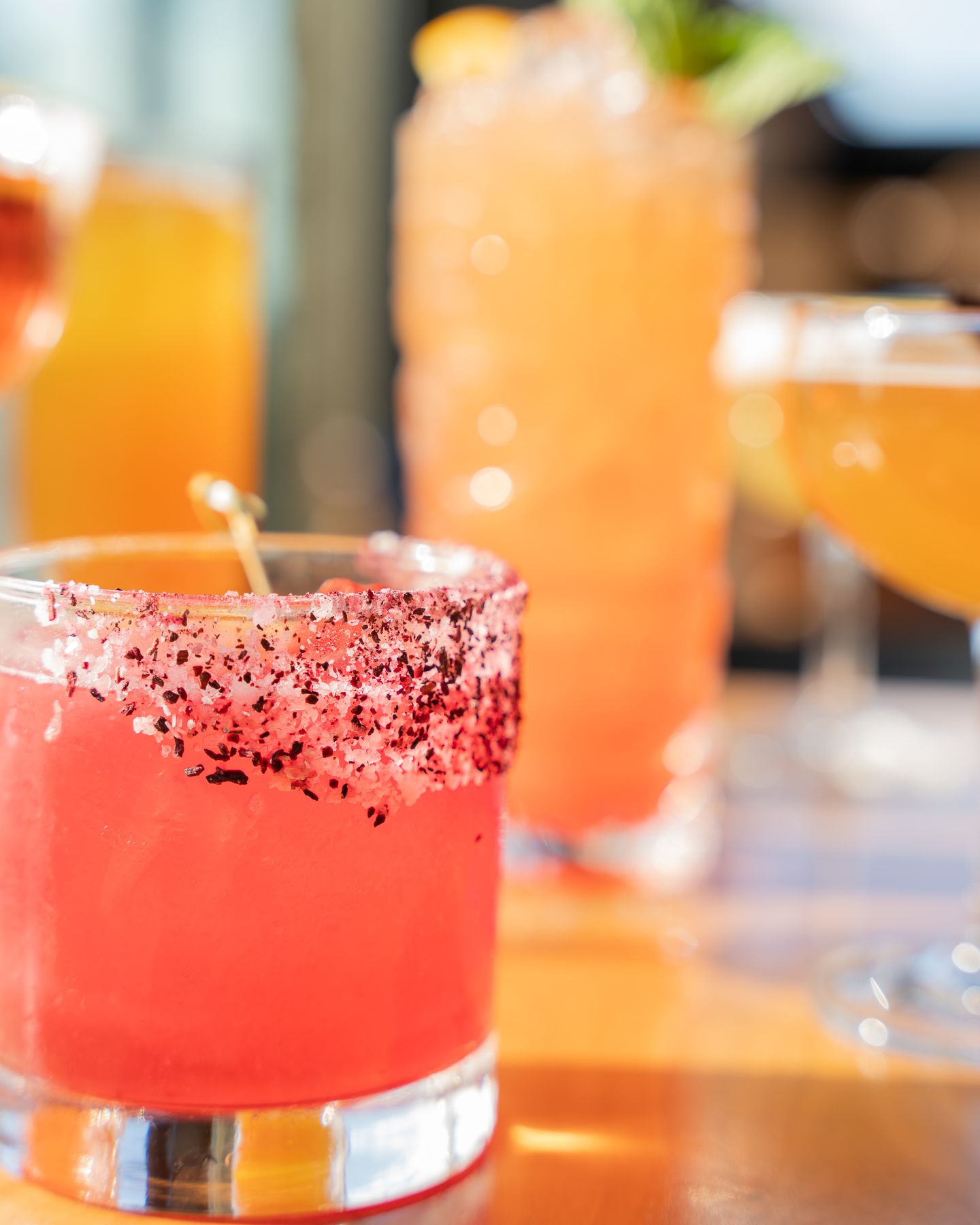 A table full of colorful cocktails on a wooden table for a commercial photography shoot