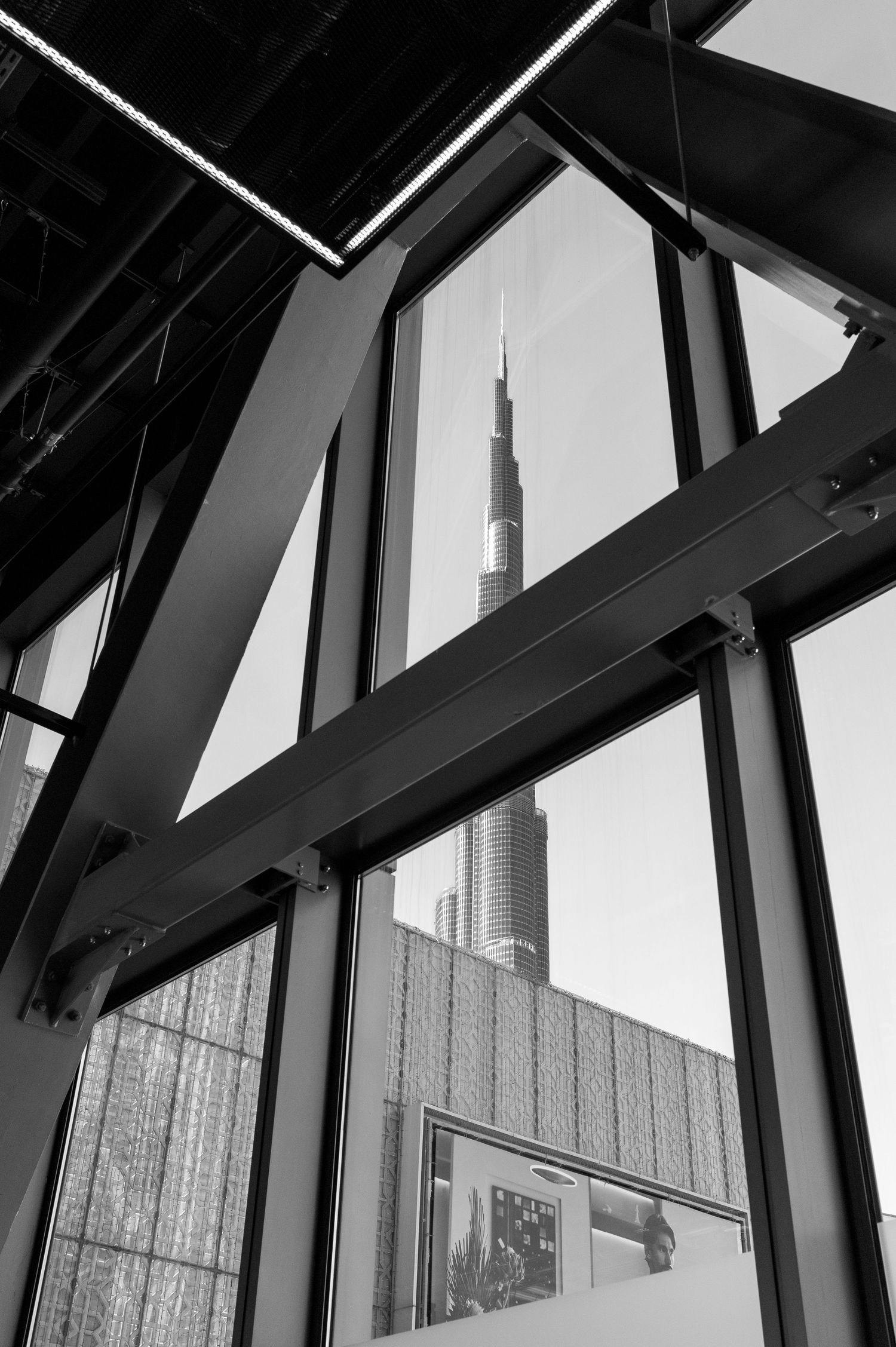 Black and white architectural view through a window frame showing the Burj Khalifa, world's tallest freestanding building, Dubai.