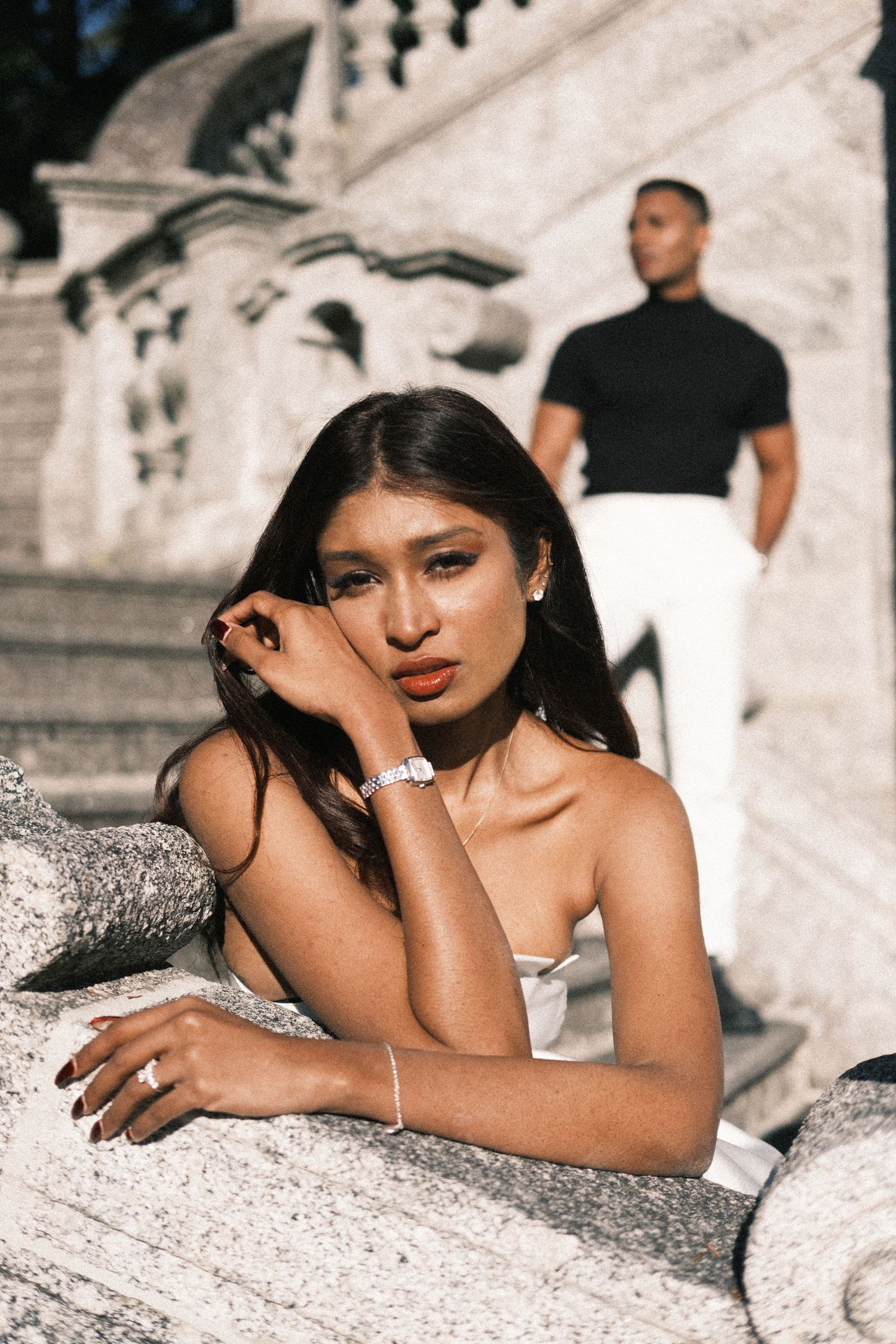 A series of artistic outdoor portrait photos showing a person laying on textured stone in dramatic lighting and poses.
