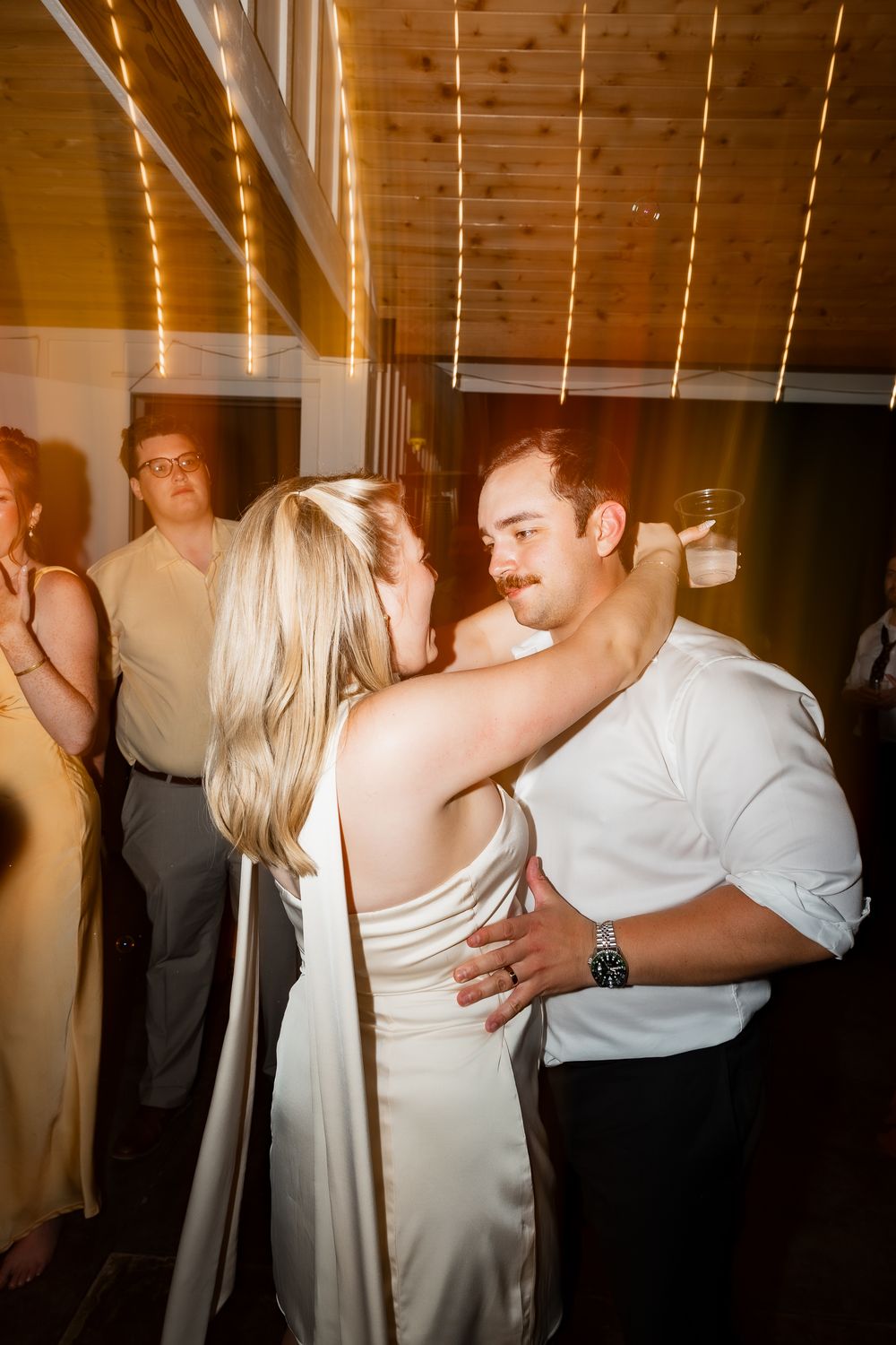 A series of dance photos showing couples slow dancing at a wedding reception with warm lighting.