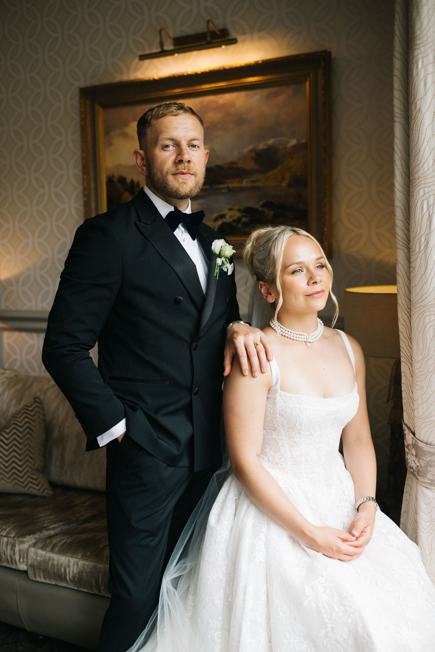 Romantic winter wedding couple walking on cobblestone street with bride wearing white fur shawl over gown. Manchester City centre wedding.