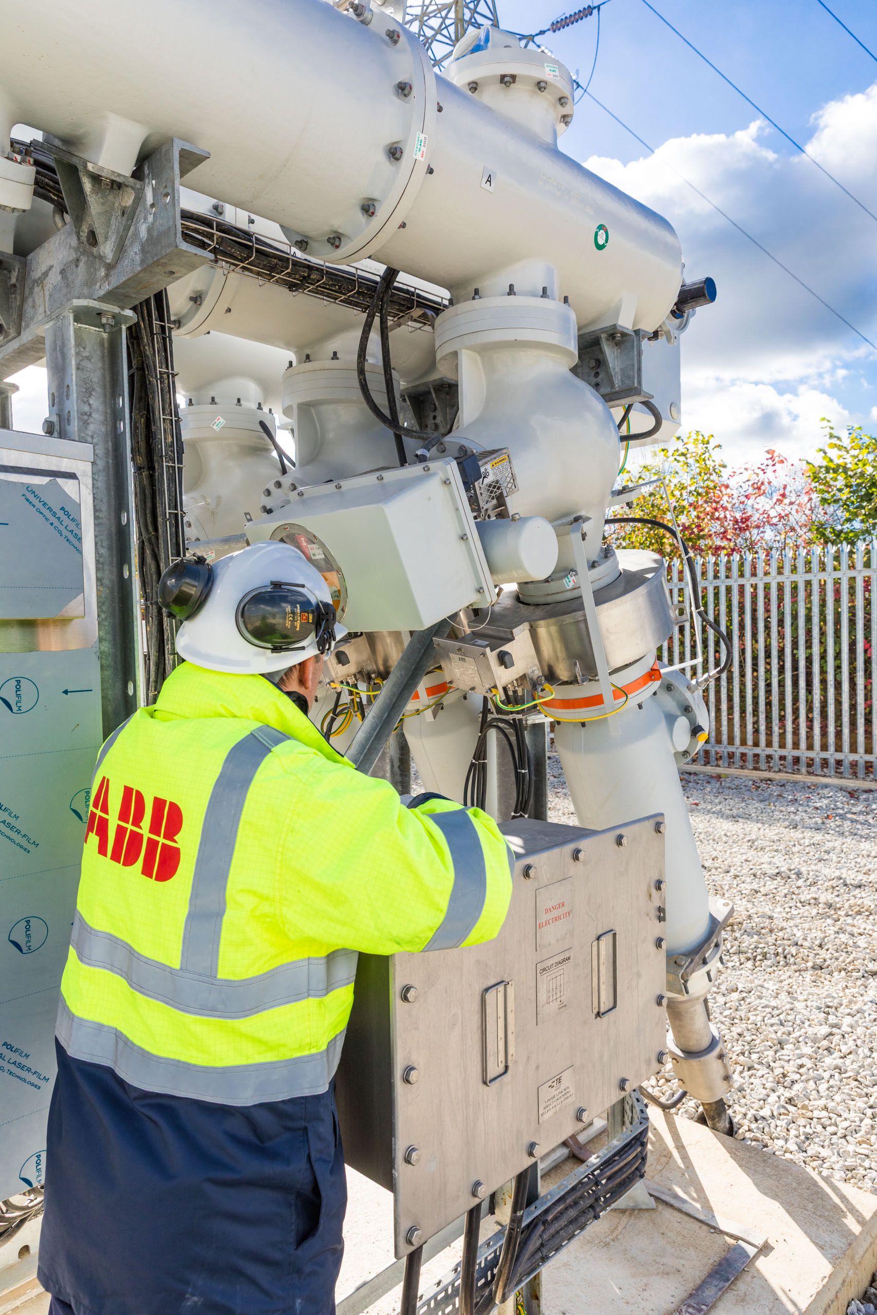 Site engineer in full PPE working on an ABB grid connection at a renewable energy facility -14