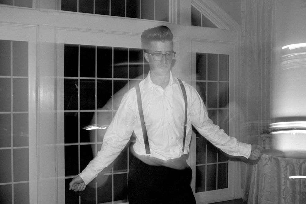 A black and white photo series showing someone in suspenders dancing and moving across multiple frames.