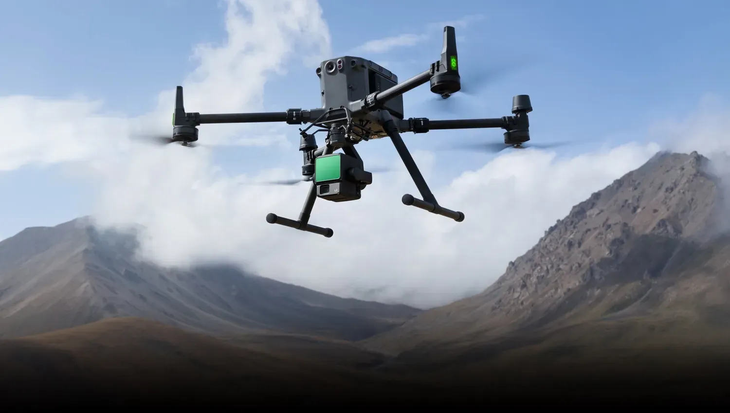 Industrial drone flying against mountainous backdrop with specialized payload attachment.