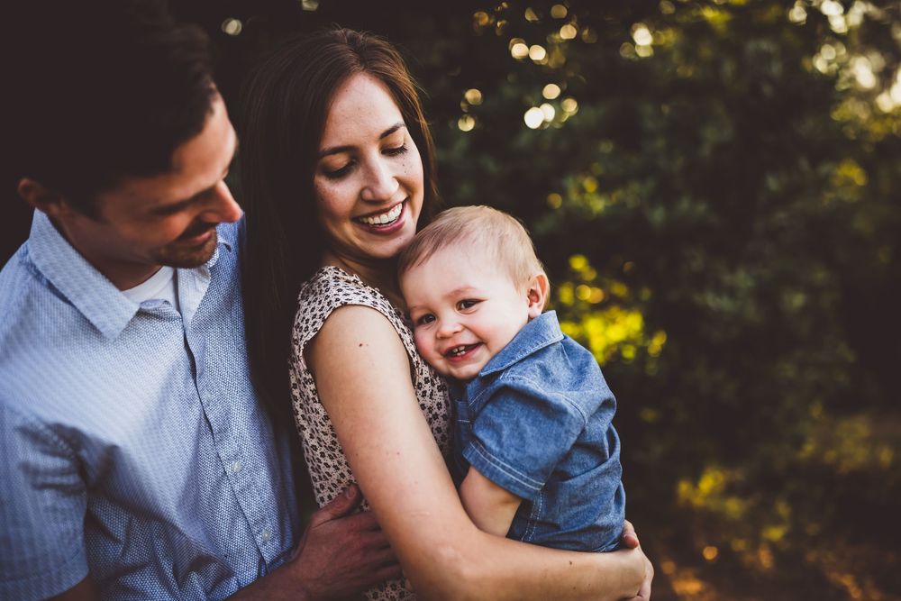 Loving family shares joyful moments together outdoors in natural lighting.