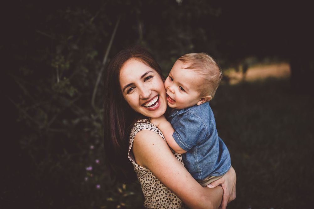 A joyful moment captured in a series of candid outdoor family photos with natural lighting and greenery in the background.