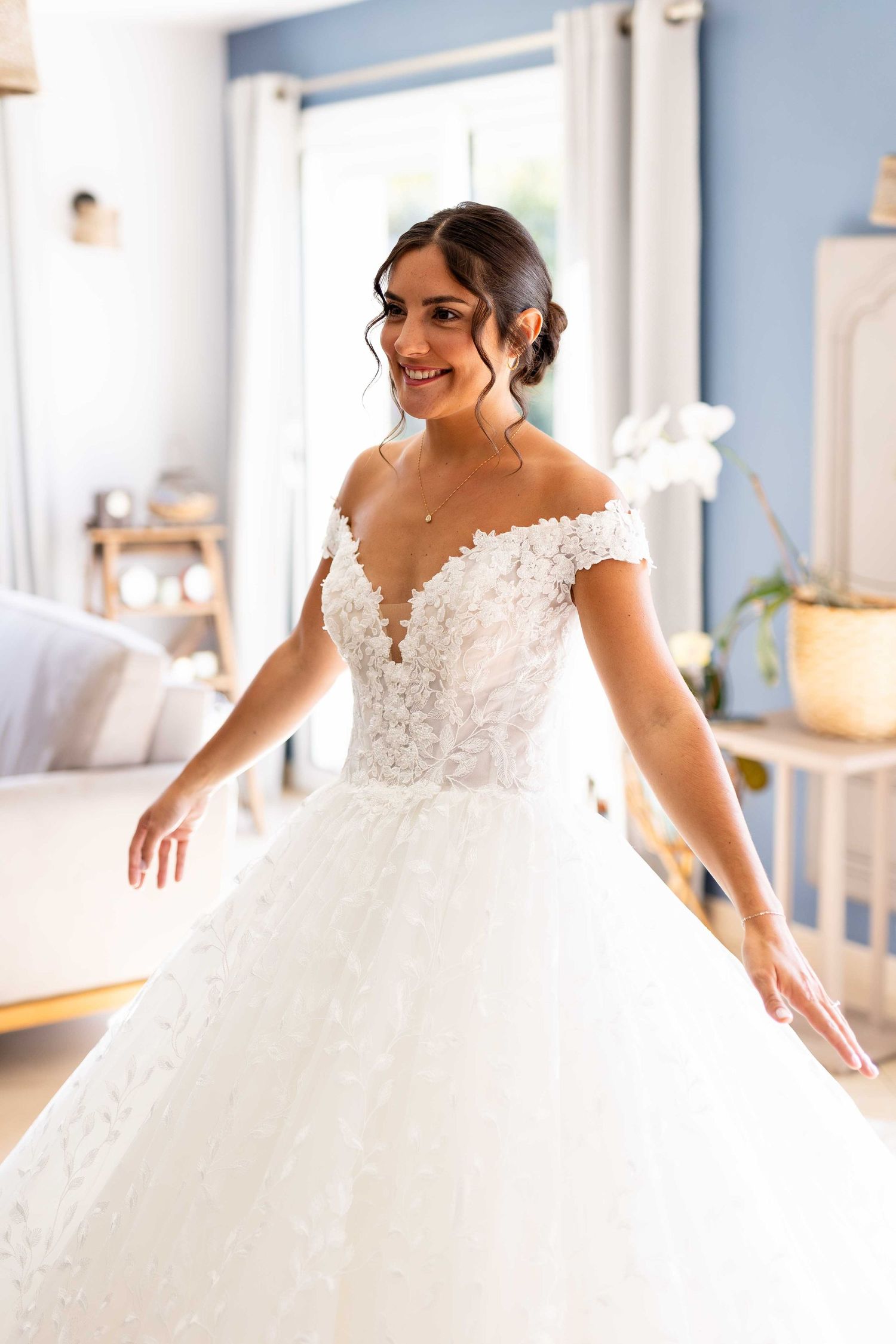 Une superbe robe de mariée avec des détails en dentelle aux épaules dénudées, une jupe en tulle volumineuse