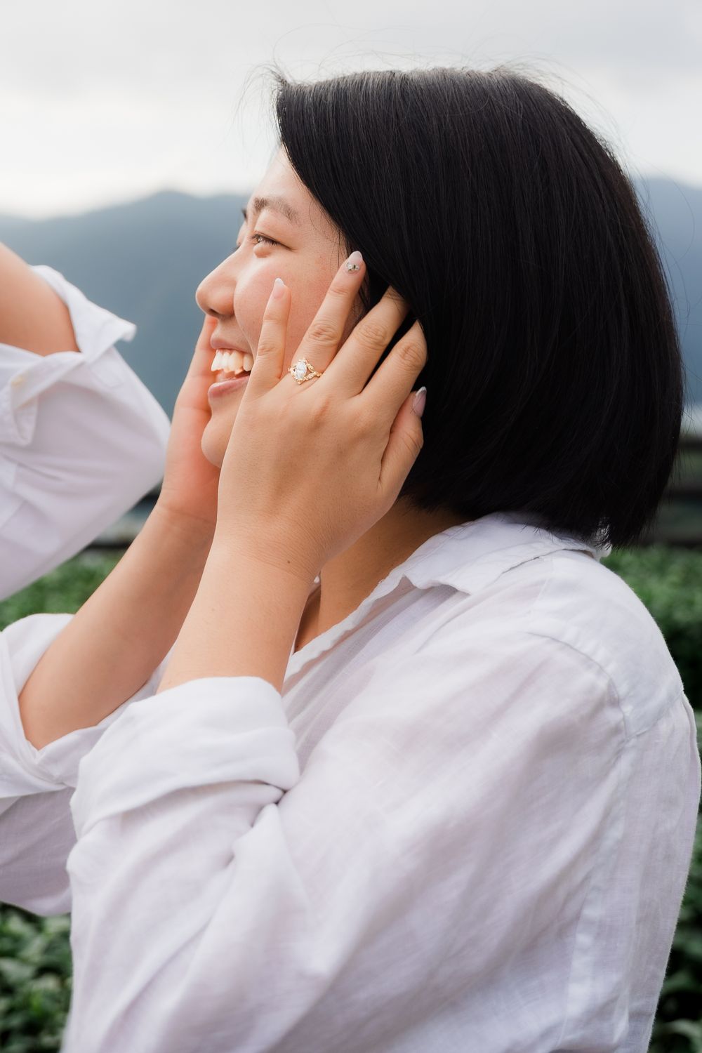 A series of photos showing someone in a white shirt covering their face with their hands against a cloudy background.