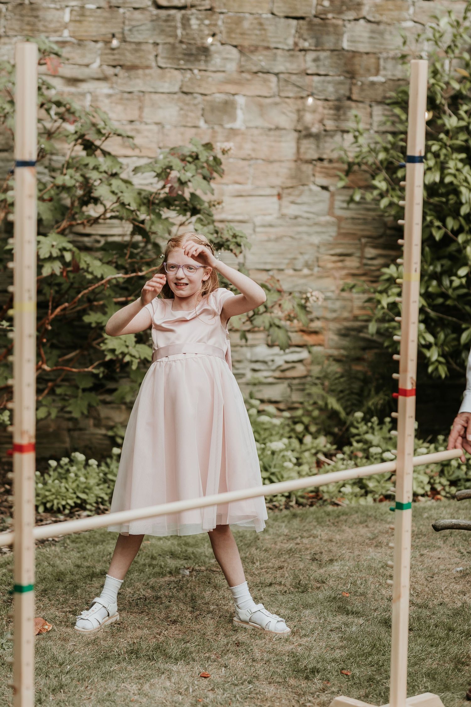 Two women enjoying outdoor activities with one wearing a floral white dress standing near exercise equipment in a park setting.