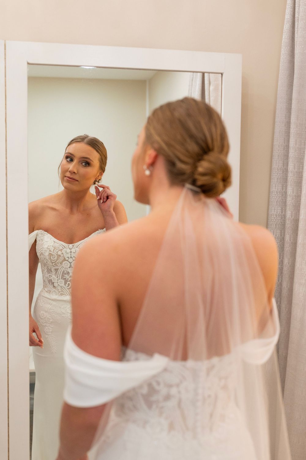 A reflection in a mirror shows final touches being made to wedding day preparations.