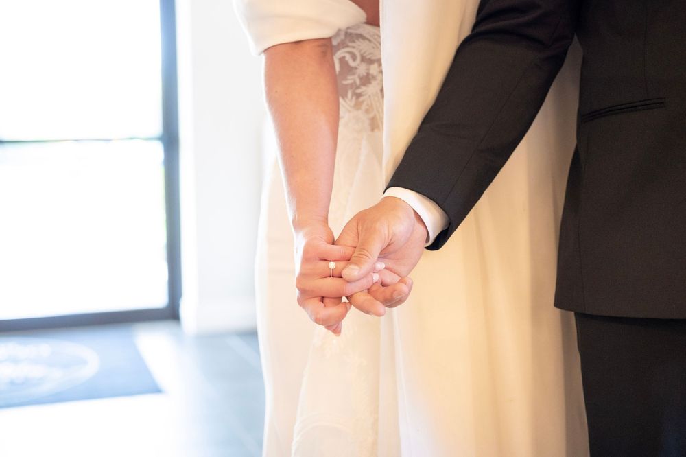 Wedding ceremony details showing formal attire and decor in an indoor setting.