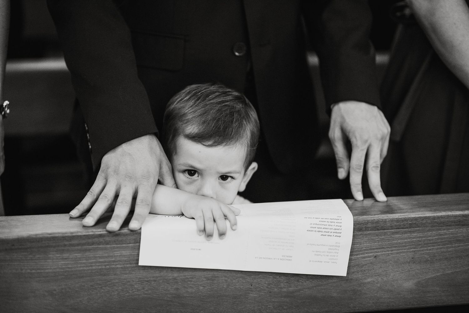 Close-up view of hands signing wedding documents at a table.
