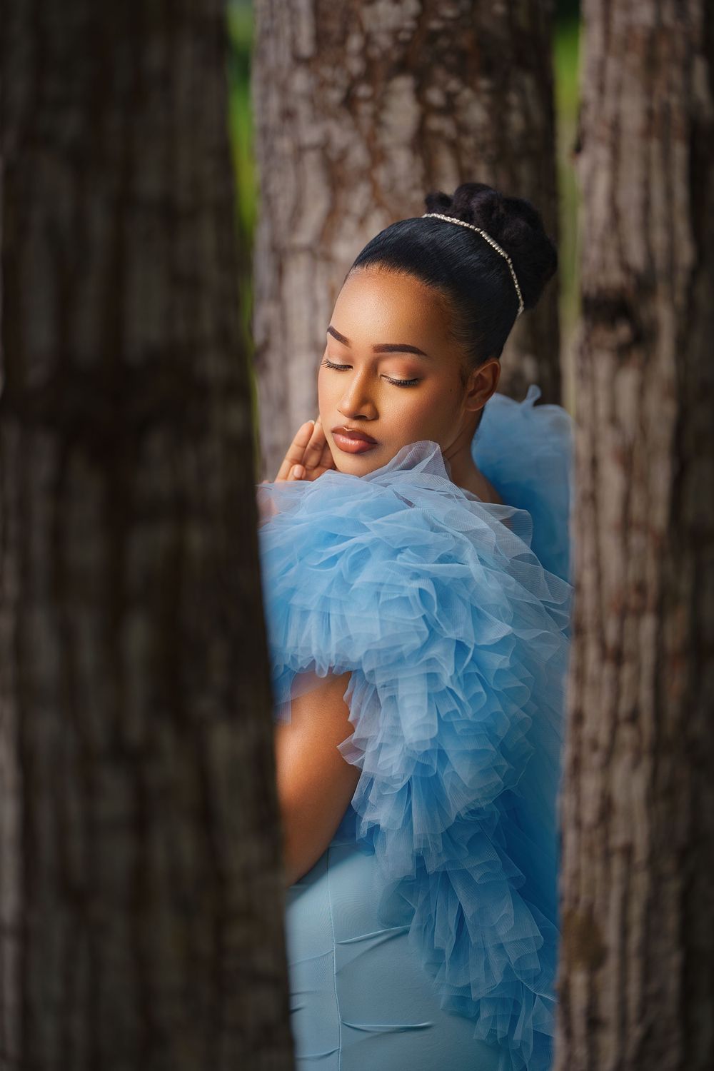 A series of artistic portraits featuring a light blue tulle dress against a natural forest backdrop.