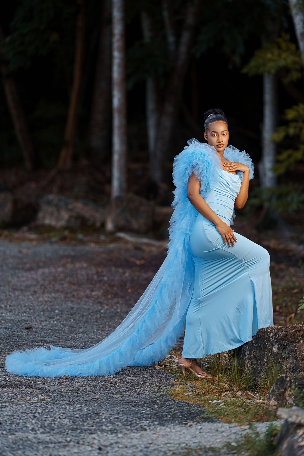 Dynamic fashion poses on a gravel path showcasing a flowing light blue gown with dramatic tulle details.