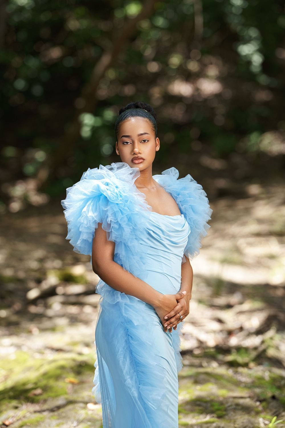 Multiple shots of someone posing in a light blue dress against a natural outdoor background with dappled sunlight.