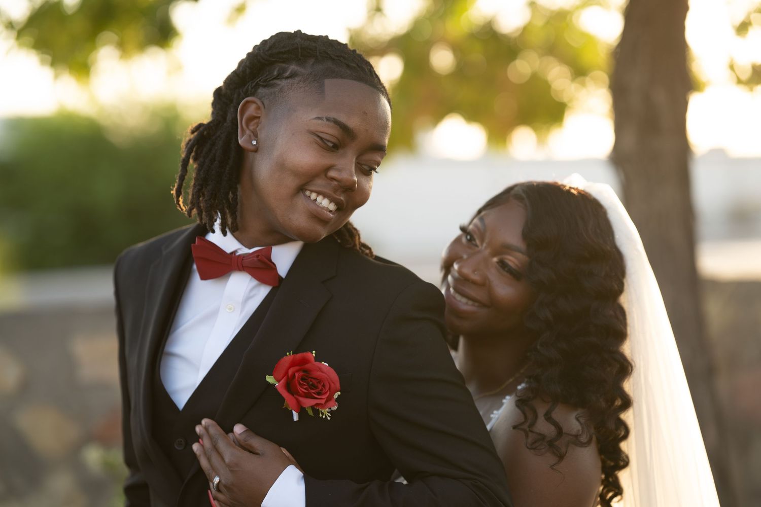 A couple shares a joyful moment together during a sunset wedding photo session.
