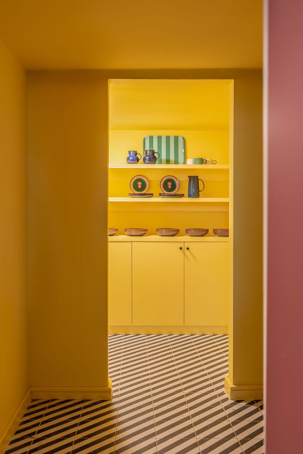 Yellow modern pantry with  entryways and diagonal  black and white pattern on the floor Colour drenching trend,