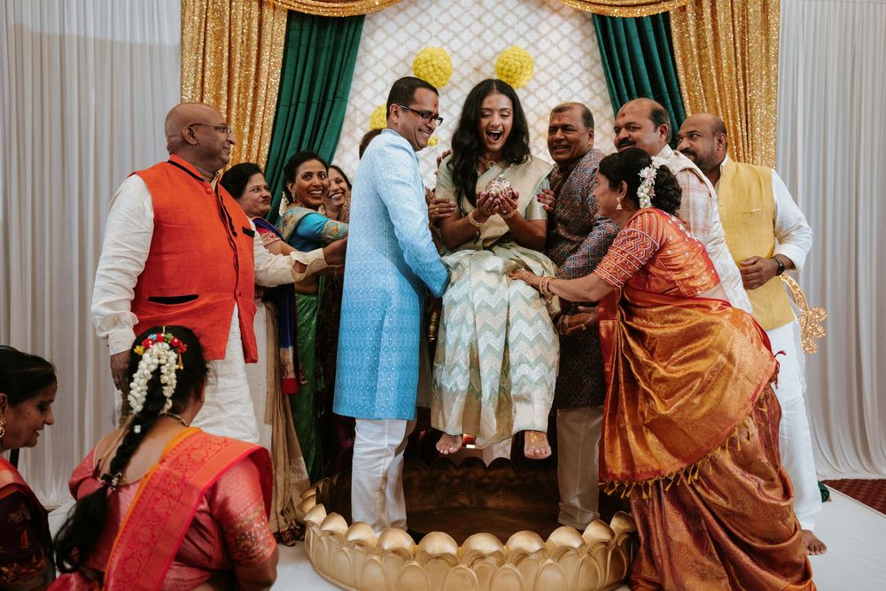 Festive Indian wedding celebration with guests in colorful traditional attire gathered in a banquet hall.