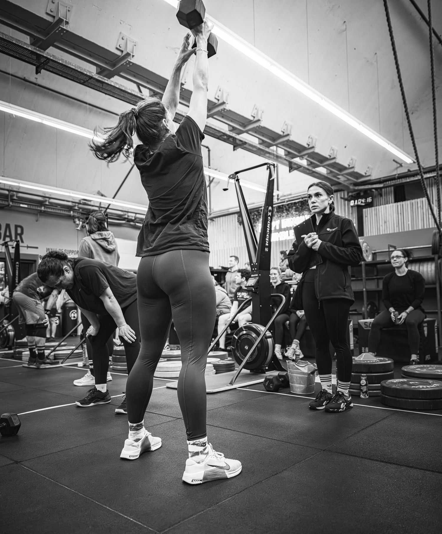 Athletes practicing dynamic barbell movements during a group fitness class.