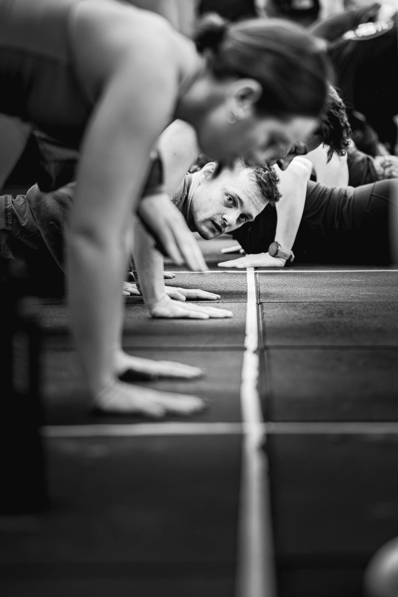 Athletes in planking position on wooden platforms during fitness training.