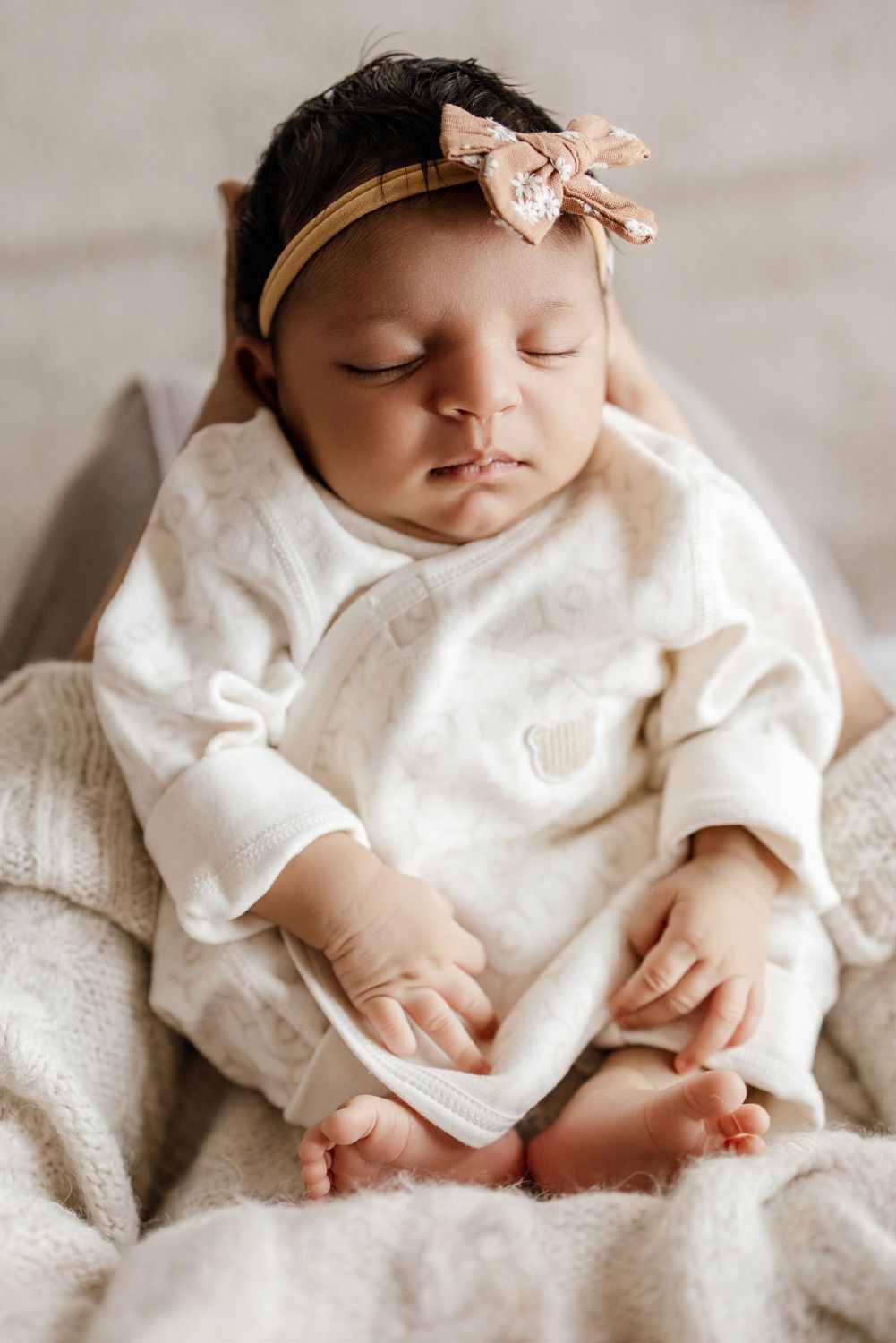 A mom holds her newborn baby for a closeup photo during their in-home session in San Jose