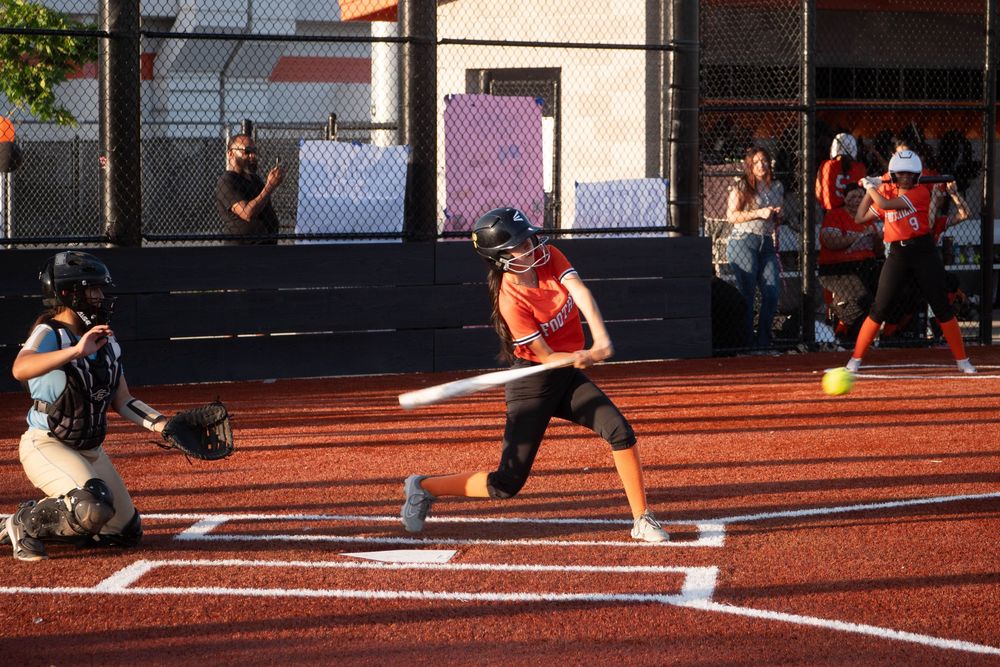 Athletes practicing sliding drills on a red track surface in a sequence of dynamic training movements.