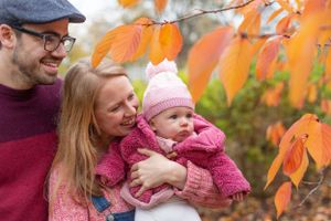 Family admiring vibrant autumn leaves on a crisp fall day.