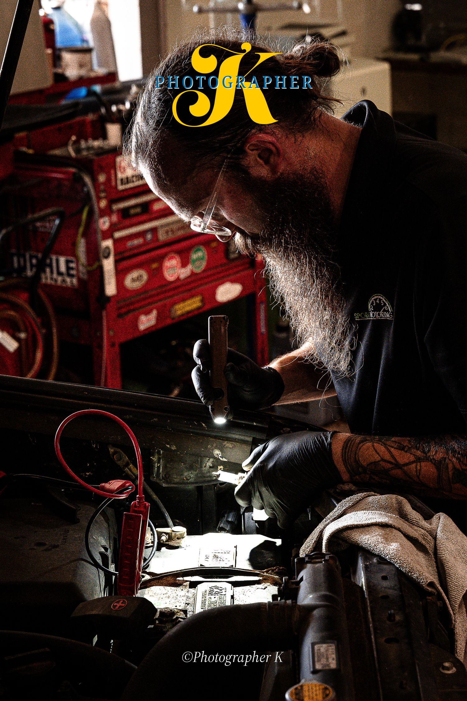 Craftsperson working intently on a detailed project in dramatic lighting with tools and equipment.